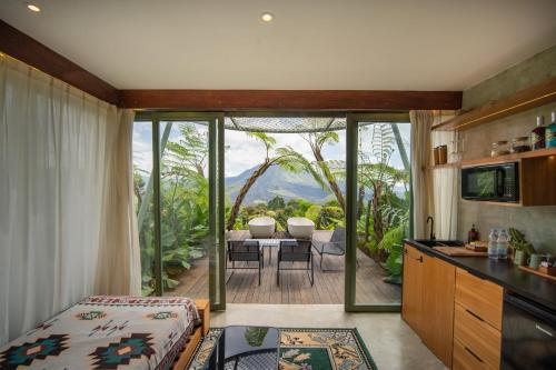 a kitchen and living room with a table and chairs at Black Wood Cabin in Kintamani