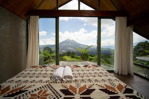 a bedroom with a bed with a view of a mountain at Black Wood Cabin in Kintamani