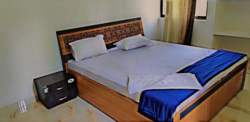 Schlafzimmer mit einem großen Bett mit einem Kopfteil aus Holz in der Unterkunft Glamour Palace in Bodh Gaya