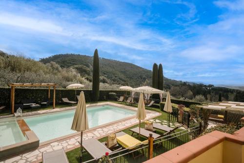einen Pool in einem Resort mit Sonnenschirmen und Stühlen in der Unterkunft Villa Sassina in La Cava