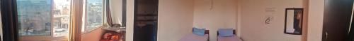 uma sala de estar com uma janela e um quarto com em Sharma atithi bhavan em Prayagraj