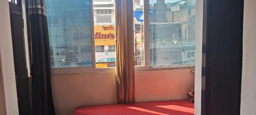 uma janela aberta com um assento vermelho em frente a uma janela em Sharma atithi bhavan em Prayagraj