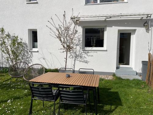 a wooden table and chairs in the yard of a house at Bohlinger Seeapartments in Bohlingen