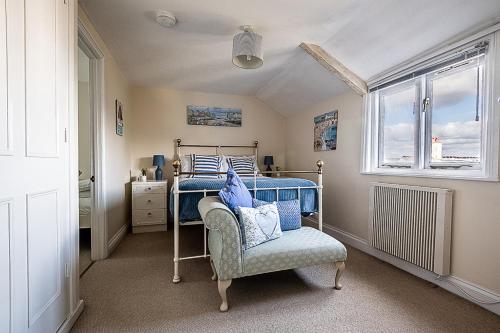 a bedroom with a bed and a chair and a window at Cosy cottage in harbourside - Pass The Keys in Cockwood