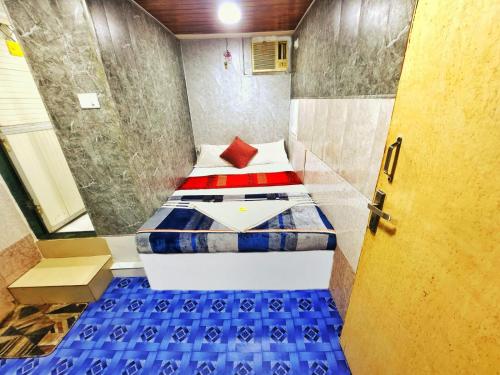 um pequeno quarto com uma cama e uma porta em HOTEL AMAAN PALACE em Mumbai