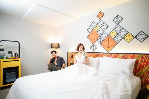 a woman sitting on a bed with a man at ibis Styles Bangkok Silom in Bangkok