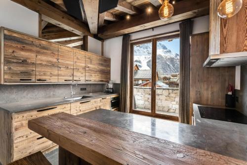 a kitchen with wooden cabinets and a large counter top at Résidence Grizzly - Pièces 544 in Val-d'Isère