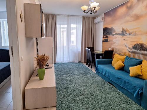 - un salon avec un canapé bleu et une table dans l'établissement Cazare Apartament 2 camere, à Chiajna