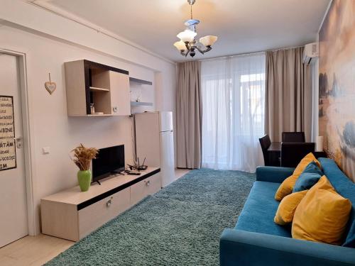 un salon avec un canapé bleu et une télévision dans l'établissement Cazare Apartament 2 camere, à Chiajna