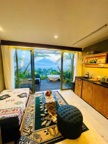 a room with a bed and a bathroom with a tub at Black Wood Cabin in Kintamani