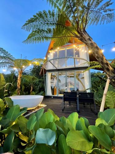 a house with a bath tub and a tree at Black Wood Cabin in Kintamani