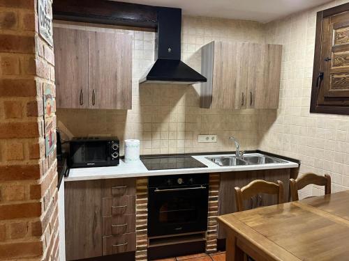 a kitchen with a sink and a microwave at EL RIBAZO-Cuenca ciudad in Cuenca