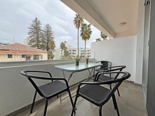a table and chairs on a balcony with a view at Albert's Apartment Center 202B in Larnaca