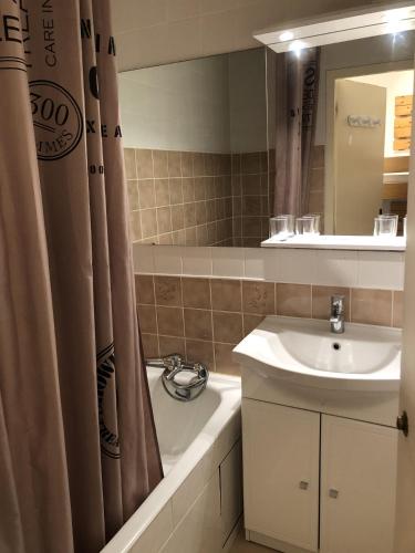une salle de bain avec un lavabo et un rideau de douche dans l'établissement Plein Sud 2106 - Studio balcon 4 pers, à Les Deux Alpes