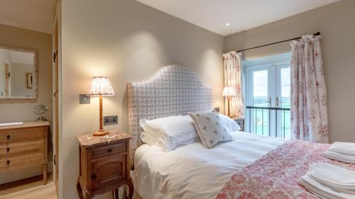 a bedroom with a large bed and a window at Golconda Cottage in Brassington