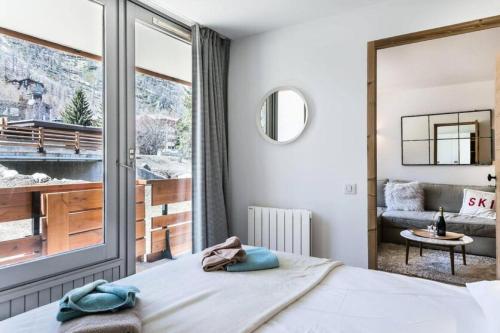 a bedroom with a bed and a large window at Residence Saint-charles - 3 Pièces pour 5 Personnes 844 in Val-d'Isère