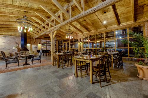 restauracja z drewnianymi sufitami, stołami i krzesłami w obiekcie Isev Kvareli w mieście Kvareli