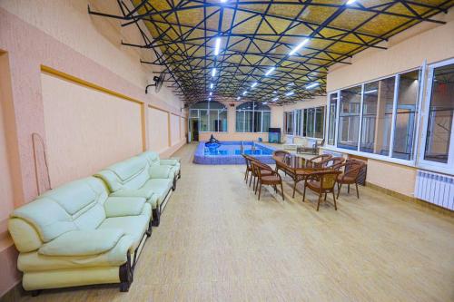 a large room with couches and a table and a pool at Сабзавот Давр Дача in Yalanghoch