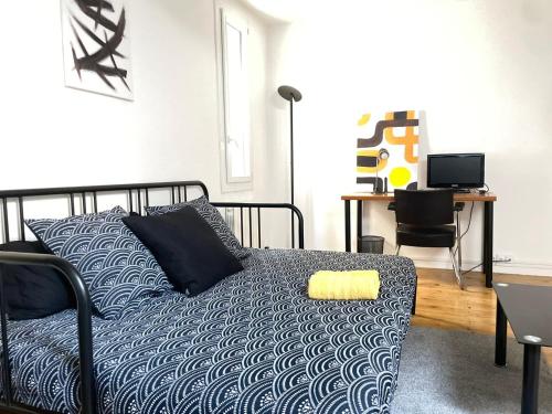 une chambre avec un lit et un bureau avec un ordinateur dans l'établissement Studio sous les toits, à Nîmes