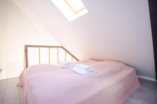 a pink bed with towels on it in a room at Stijlvolle @ luxe vrijstaande woning Maastricht in Eijsden