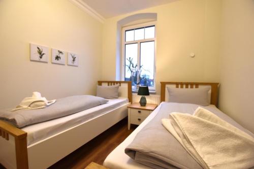 2 camas individuales en una habitación con ventana en FeWo 1 "Birkenast" 1OG inkl Strandkorb, en Dahme