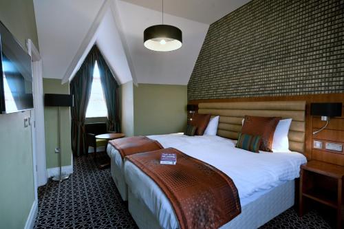 una habitación de hotel con una cama grande en una habitación en The Last Post Wetherspoon Hotel en Southend-on-Sea