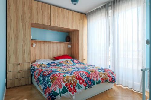- une chambre avec un lit et une couette colorée dans l'établissement Bright and charming apartment - On Boulogne, à Boulogne-Billancourt