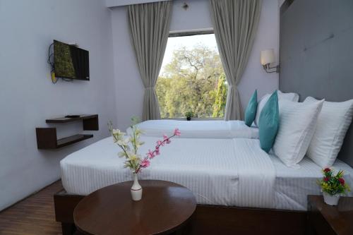 a hotel room with a large bed with a window at Hotel Clarks Collection Bhavnagar in Bhavnagar