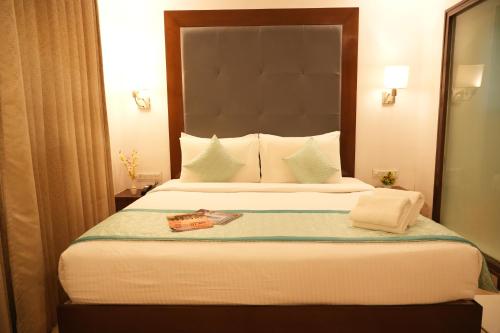 a bedroom with a large bed with a large headboard at Hotel Clarks Collection Bhavnagar in Bhavnagar