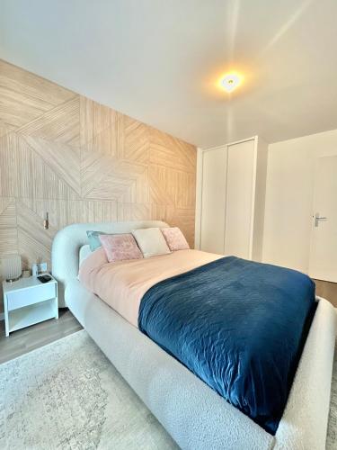 une chambre avec un grand lit avec une couverture bleue dans l'établissement Appartement raffiné à 2min du RER A, à Nanterre