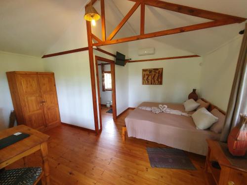 a bedroom with a bed and a wooden floor at Thokozani Lodge in White River