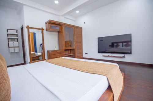 1 dormitorio con 1 cama y TV de pantalla plana en Wenasa Villa en Diyatalawa