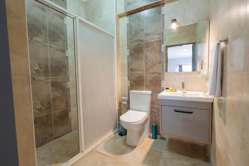 y baño con aseo, lavabo y ducha. en LESLION HOTEL TURUNC en Marmaris