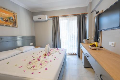 a hotel room with a bed with flowers on it at LESLION HOTEL TURUNC in Marmaris