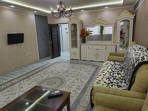 sala de estar con sofá y TV en Ганга центр люкс en Tashkent