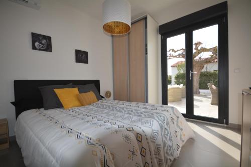 une chambre avec un grand lit et une grande fenêtre dans l'établissement Villa Pascal, à Saint-Raphaël