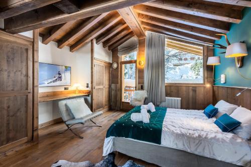 a bedroom with a bed and a desk and a chair at Résidence Prosper - Chalets pour 12 Personnes 154 in Courchevel