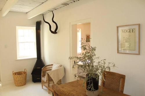 a living room with a wooden table and a plant at Huis Kandelabra in Oudtshoorn