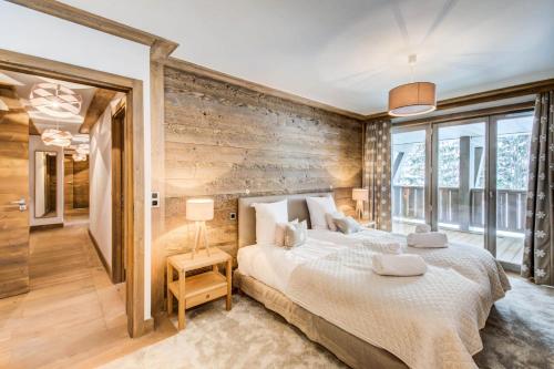 una camera con un grande letto e pareti in legno di Résidence Carre Blanc - 4 Pièces pour 6 Personnes 394 a Courchevel
