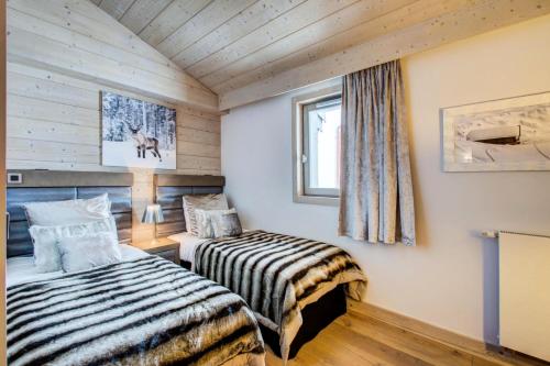 a bedroom with two beds and a window at Résidence Carre Blanc - 4 Pièces pour 6 Personnes 404 in Courchevel
