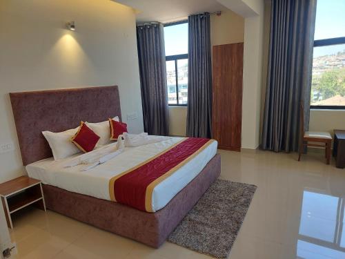 a bedroom with a large bed with a large window at CAPITAL LODGE in Madikeri