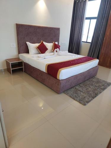 ein Schlafzimmer mit einem großen Bett in einem Zimmer in der Unterkunft CAPITAL LODGE in Madikeri