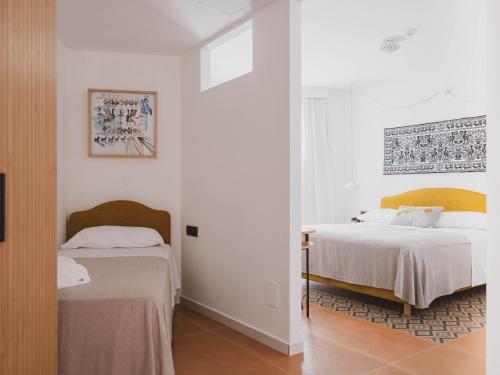 2 łóżka w pokoju z białymi ścianami w obiekcie Tramas Hotel & Spa w mieście Olbia