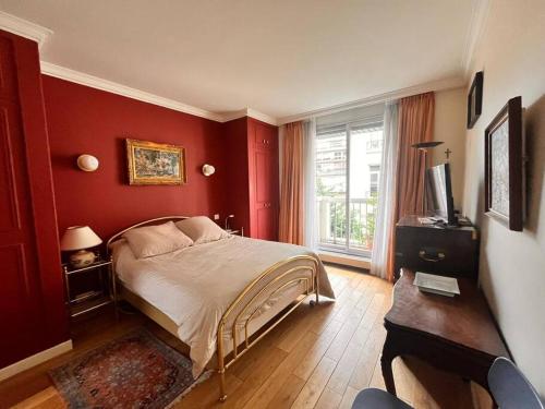 - une chambre rouge avec un lit et une fenêtre dans l'établissement 16ème - Près Trocadéro, Quartier Prestigieux, à Paris