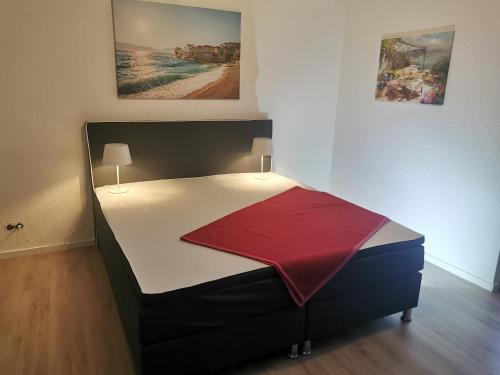 a bedroom with a bed with a red blanket on it at Apartment Messe Hannover in Garbsen