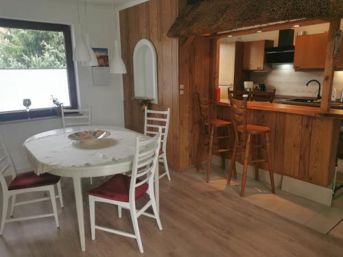 a kitchen and dining room with a white table and chairs at Apartment Messe Hannover in Garbsen