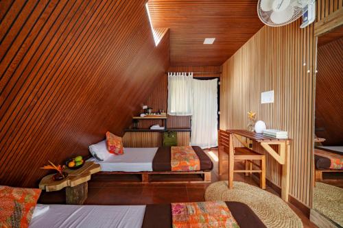 a bedroom with a bed and a desk in a room at Aya natural in Ūdumbanshola
