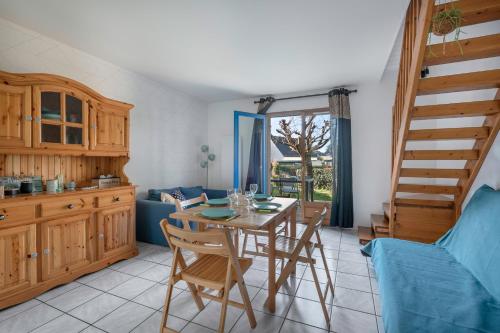 une cuisine avec une table et des chaises ainsi qu'un escalier dans l'établissement Détente et repos en famille à Piriac-sur-Mer, à Piriac-sur-Mer