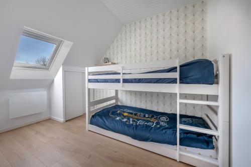 une chambre avec deux lits superposés et une fenêtre dans l'établissement Détente et repos en famille à Piriac-sur-Mer, à Piriac-sur-Mer