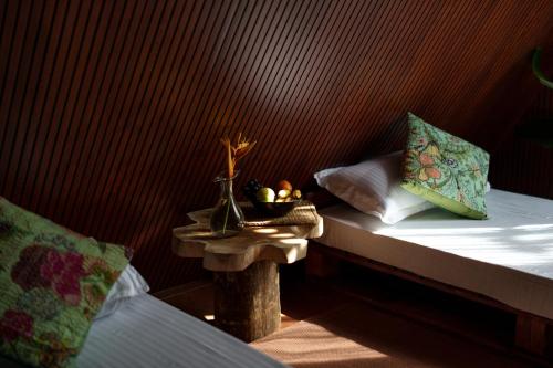 a bed with a table with a bowl of fruit on it at Aya natural in Ūdumbanshola